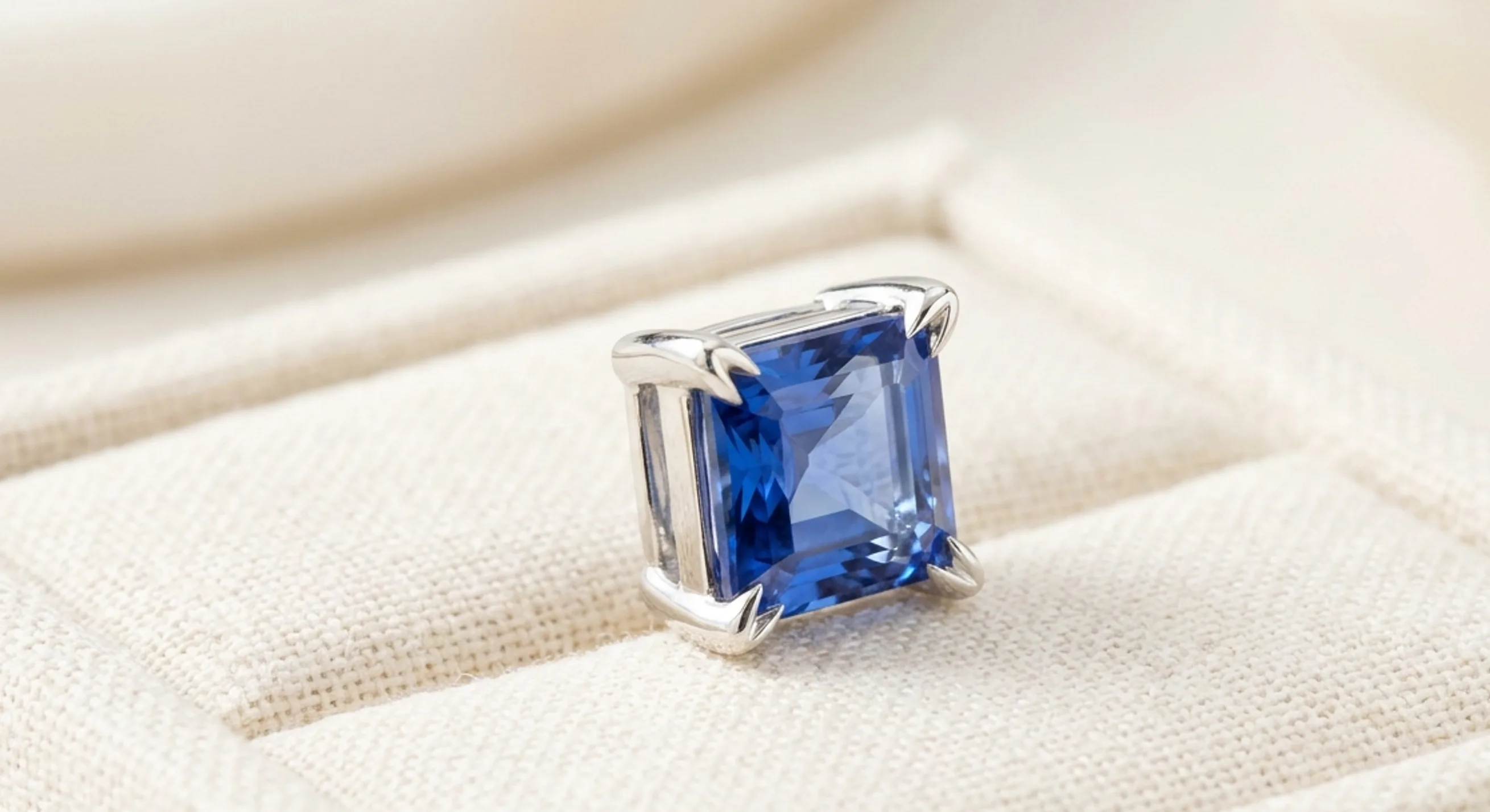 Princess-cut blue sapphire held by four V-shaped prongs that protect its corners