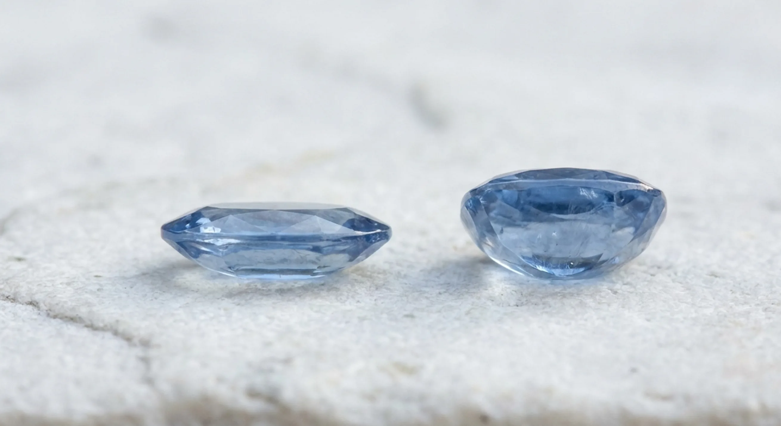 A shallow oval sapphire and a deep native-cut cushion sapphire shown side by side in profile