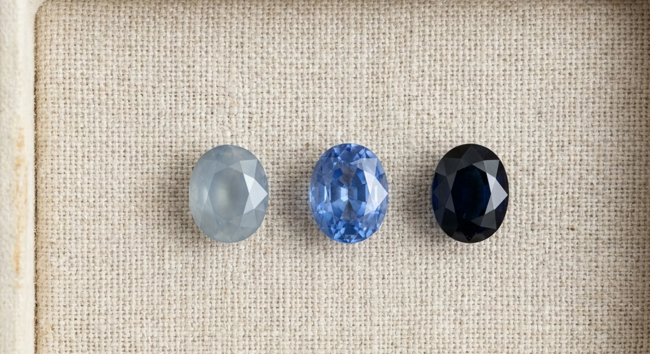 Three loose Ceylon blue sapphires in a row showing pale, medium cornflower and very dark tones
