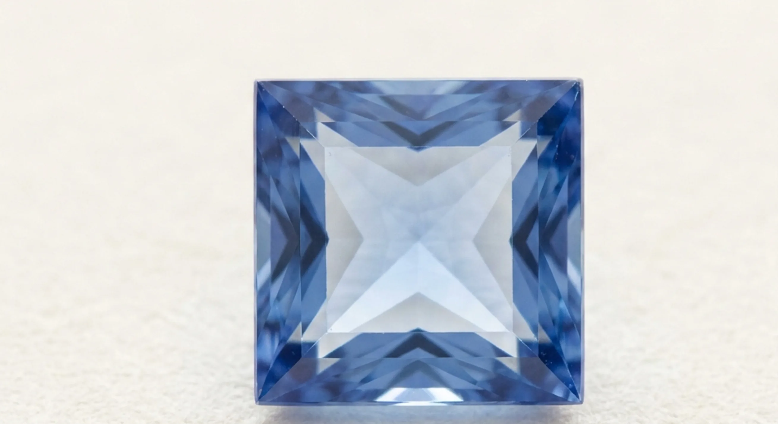 Face-up princess cut cornflower-blue sapphire with a lighter centre and deeper blue corners