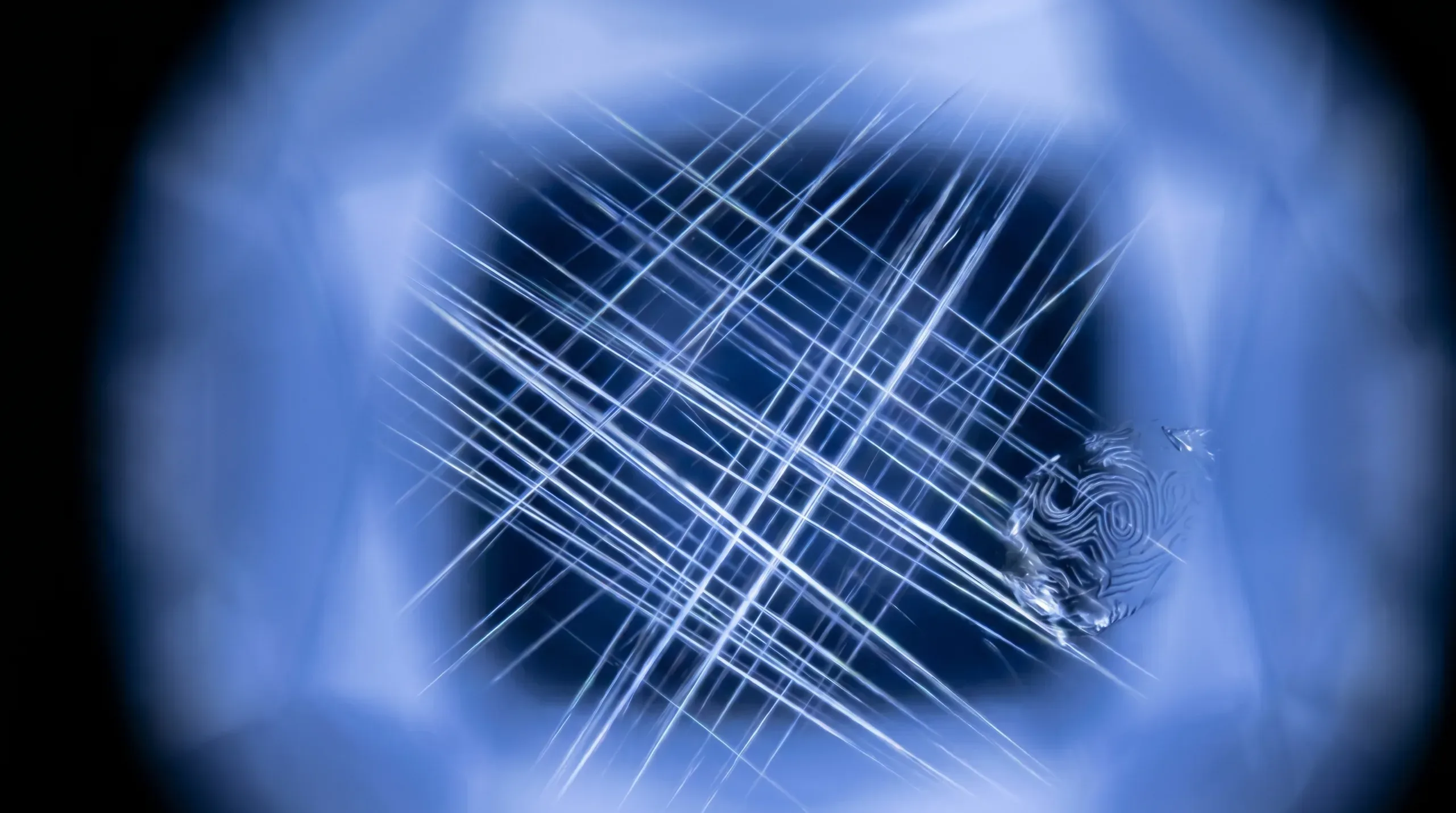 Photomicrograph into a blue sapphire: intact rutile silk needles in a sharp grid pattern and a fingerprint-style inclusion, typical of natural material before heat dissolves silk.