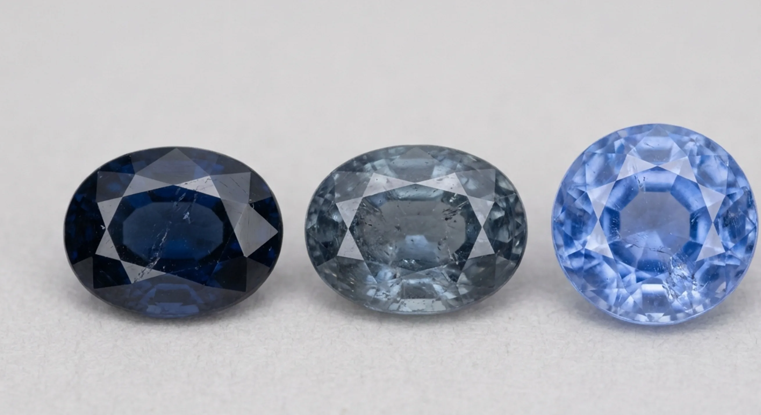 Three loose Ceylon sapphires showing dark, greyed and true cornflower blue side by side