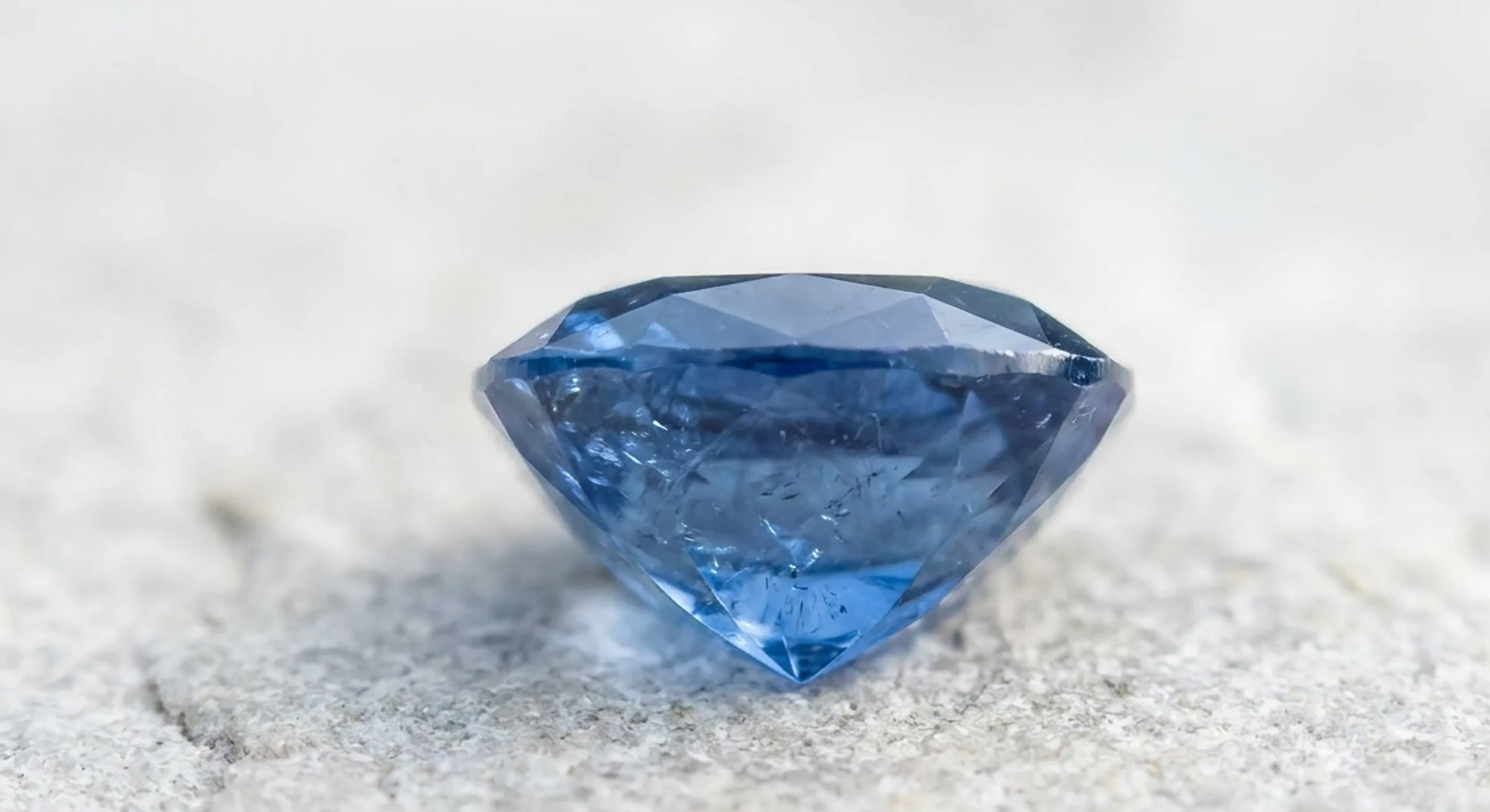 Side view of a cushion sapphire showing its crown, girdle and gently curved pavilion