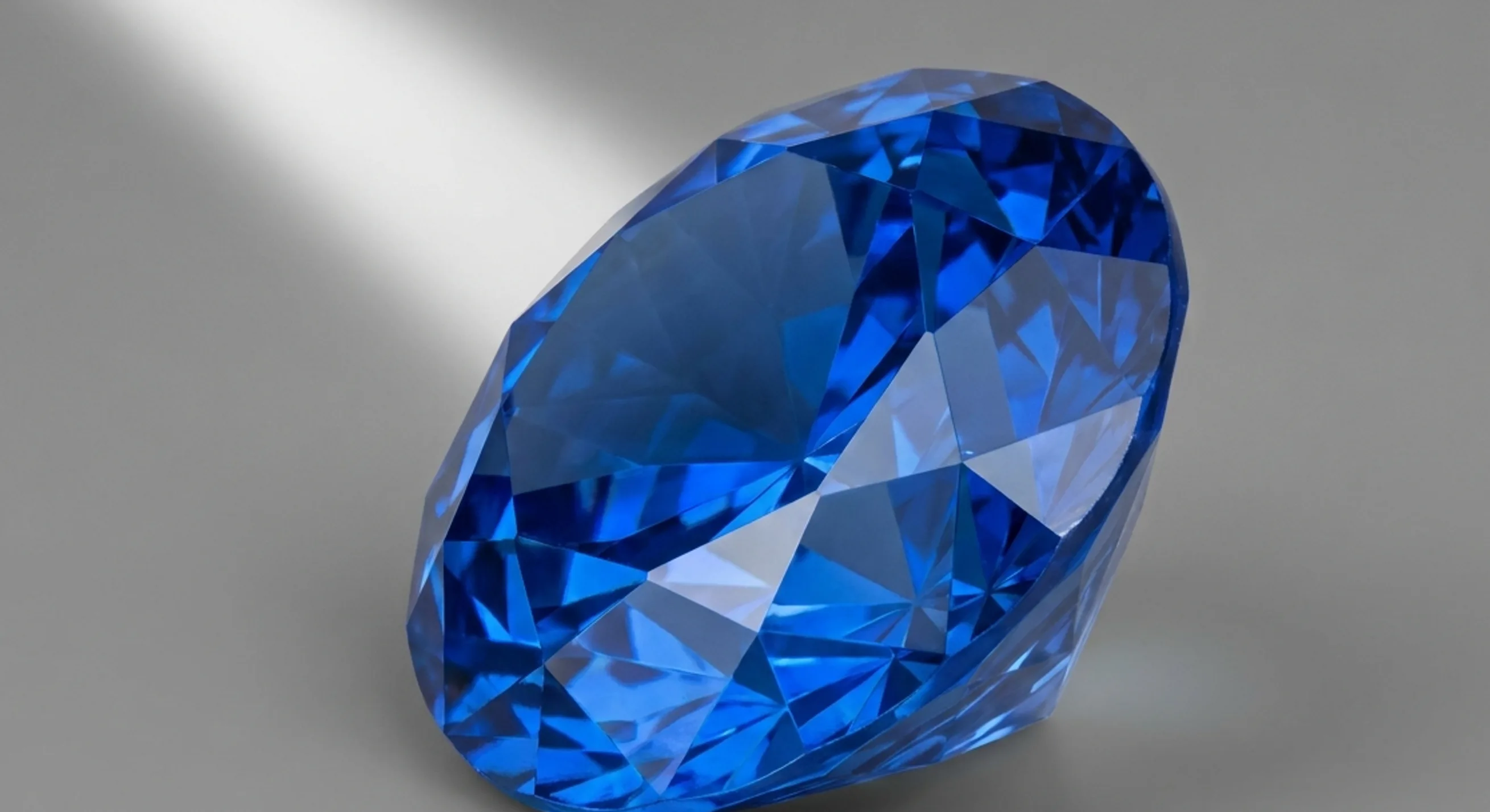 A tilted blue sapphire showing its cut and light return across the facets