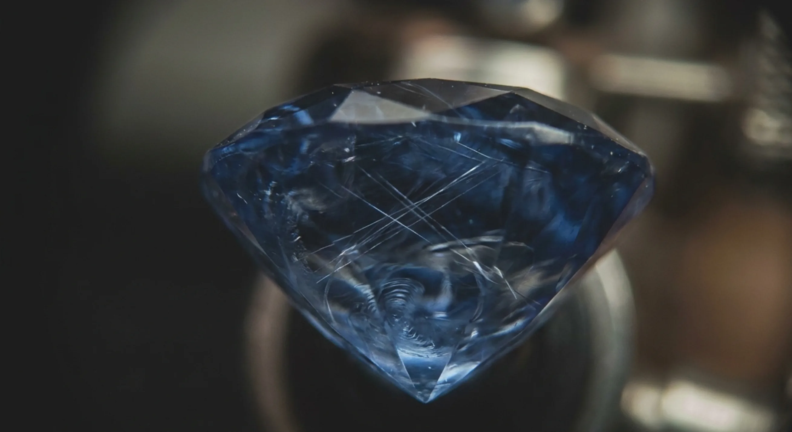 Magnified interior of a natural blue sapphire showing silk and fingerprint inclusions