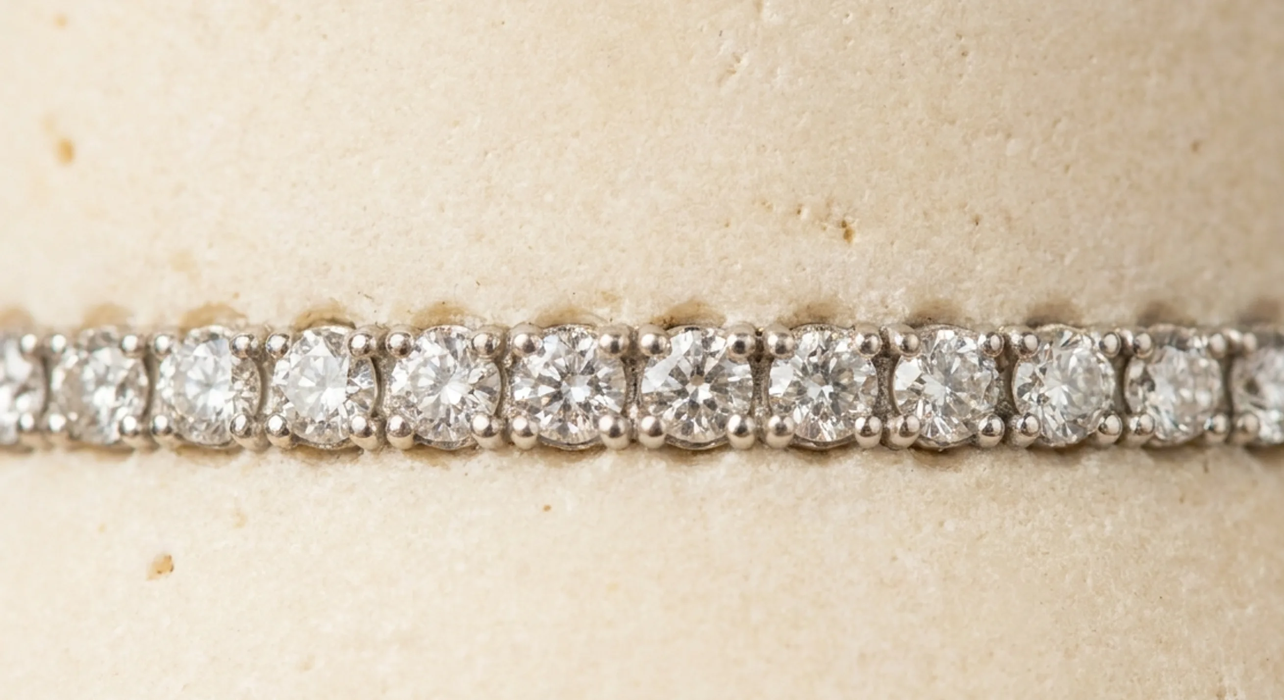 Macro view of pavé diamonds held by tiny metal beads in a close-set row